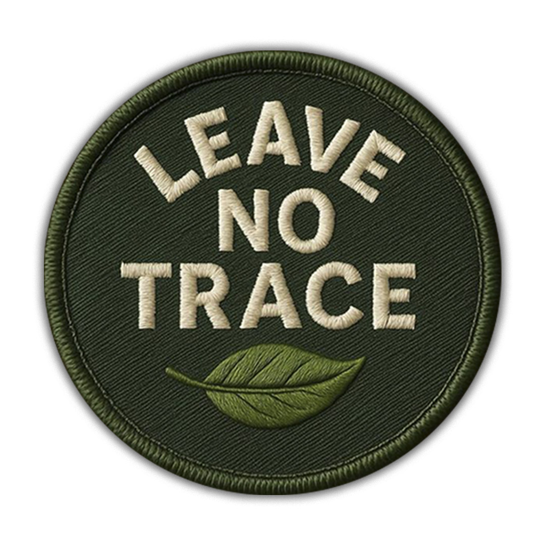 Round dark green embroidered patch with white text LEAVE NO TRACE and a green leaf icon.